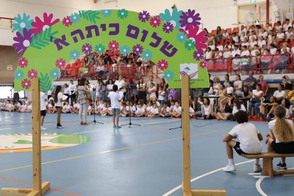 שלט שלום כיתה א באולם מלא תלמידים