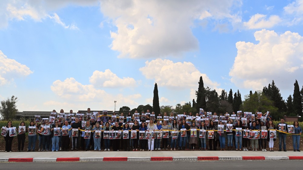 עובדות ועובדי המועצה עם תמונותיהם של החטפות והחטופים