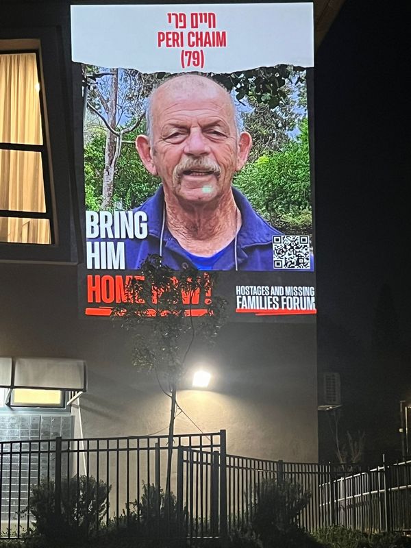 הקרנת תמונות החטופים על קיר מבנה ציבור בגבעת אלה