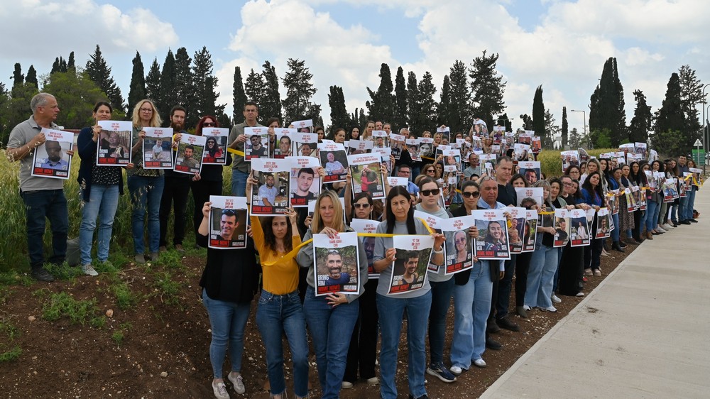 עובדות ועובדי המועצה עם תמונותיהם של החטופות והחטופים  