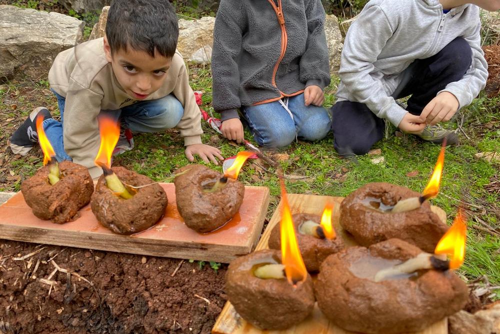 ילדים וילדות מכינים פסלוני בוץ 
